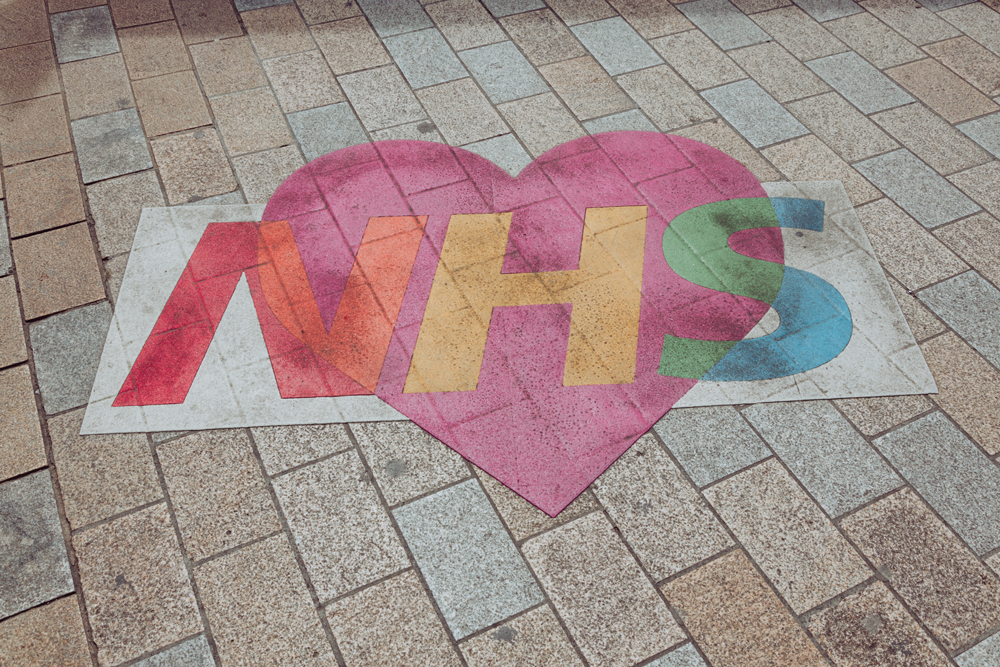 The NHS logo chalked onto the floor with a heart